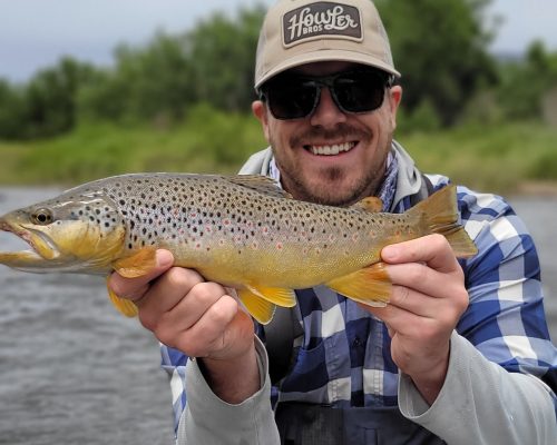 Angler holding trout during fly fishing Rio Grande Colorado adventure