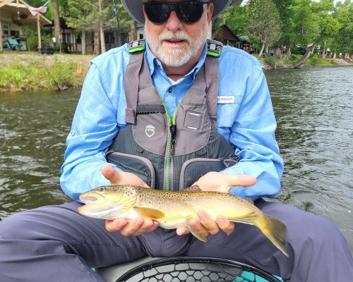 Angler displaying trout during Rio Grande River trout fishing near Del Norte Colorado